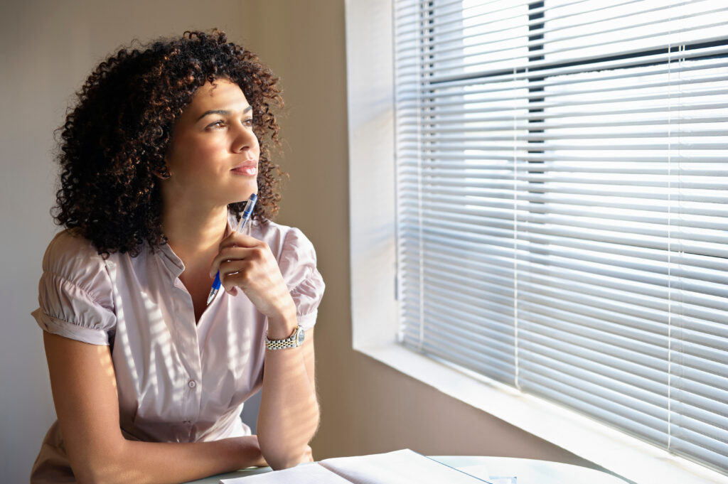 person thoughtfully looking out a window, representing nuanced thinking in mental health conversations