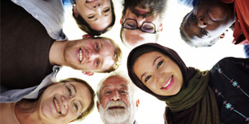 Smiling faces of people looking down in a circle