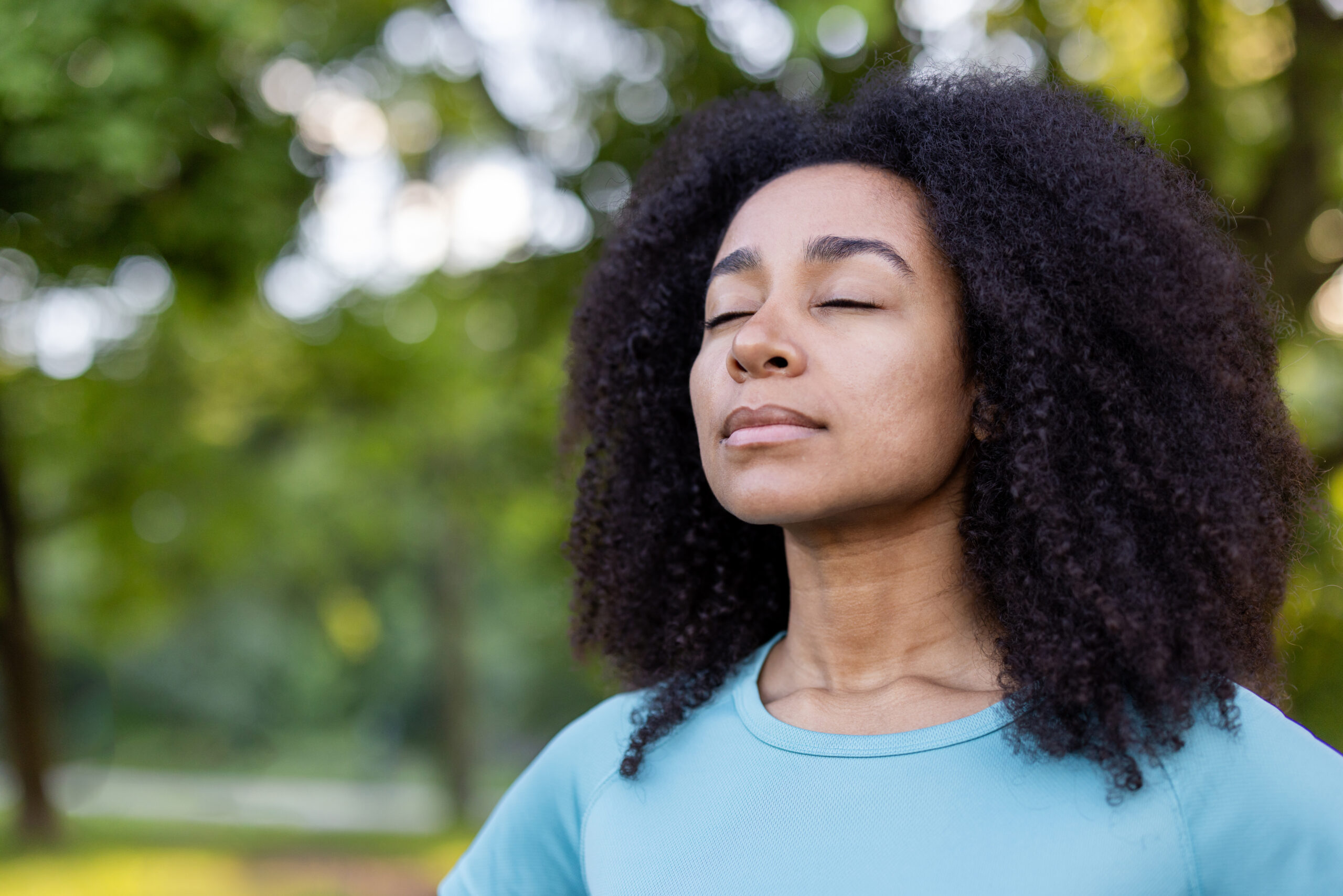 Woman practicing mindful breathing outdoors to support emotional balance and mental wellness